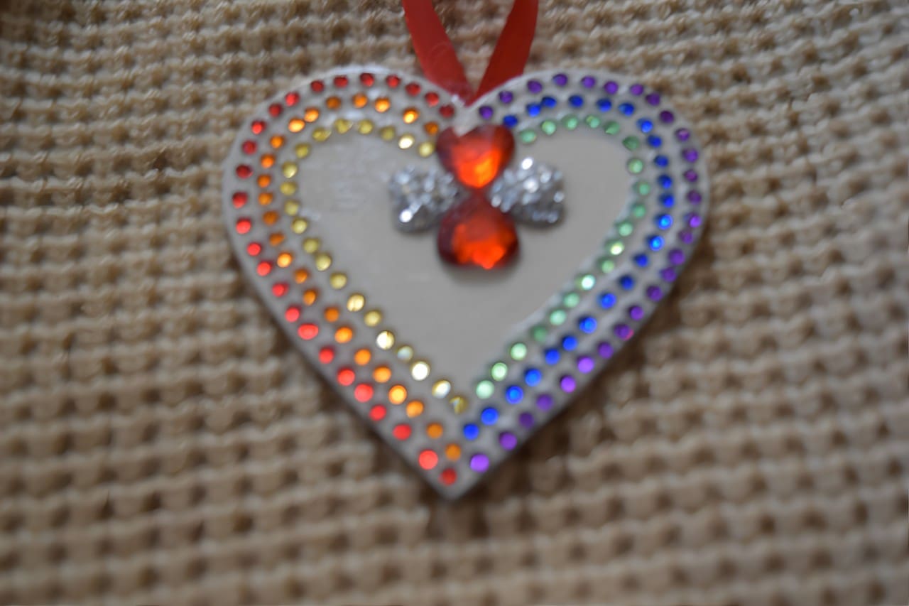 A heart shaped ornament with red and blue rhinestones.