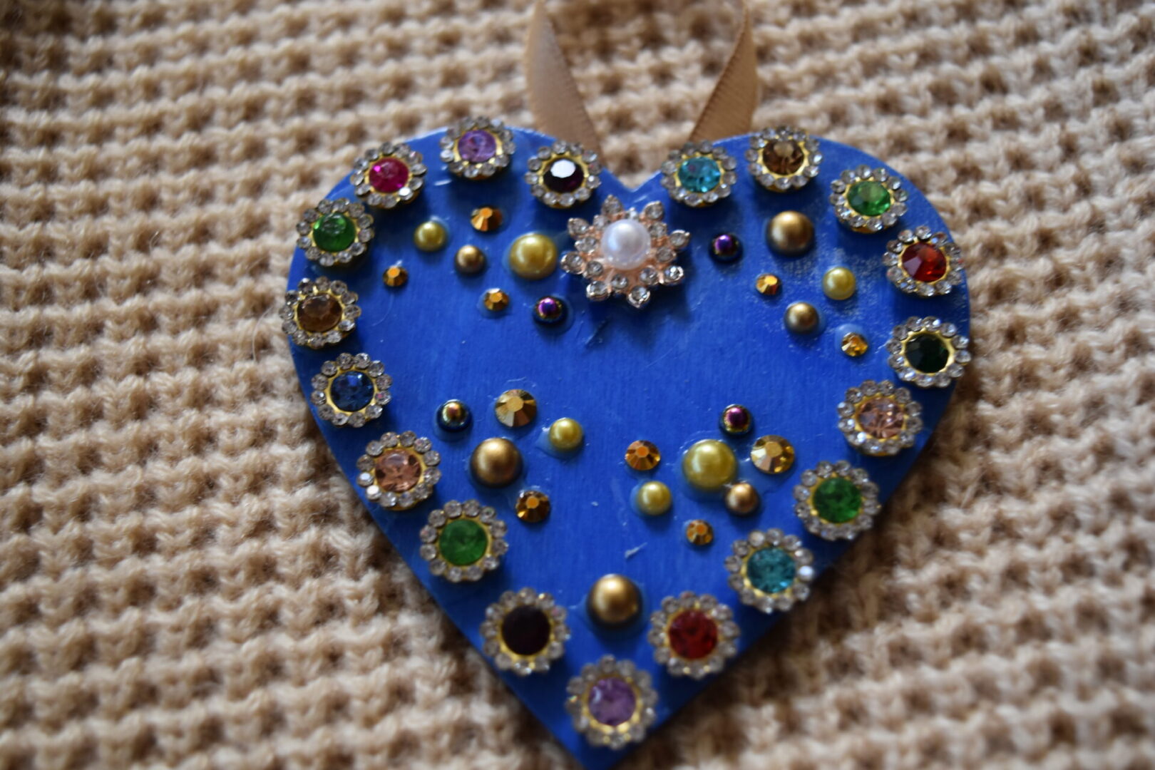 A blue heart with many different colored jewels on it.