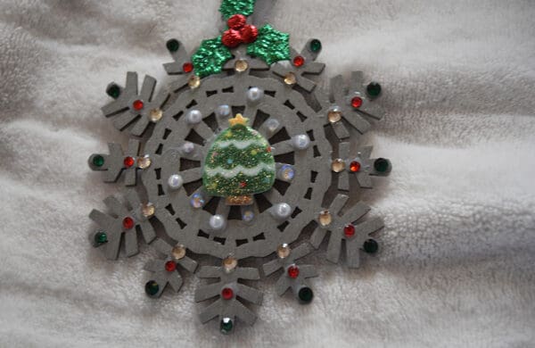 A wooden snowflake with a christmas tree on it.