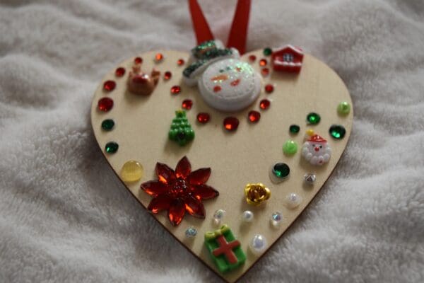 A heart shaped ornament with christmas decorations on it.