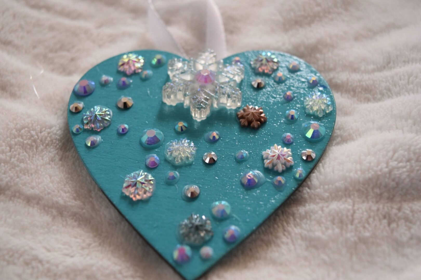 A heart shaped ornament with some jewels on it