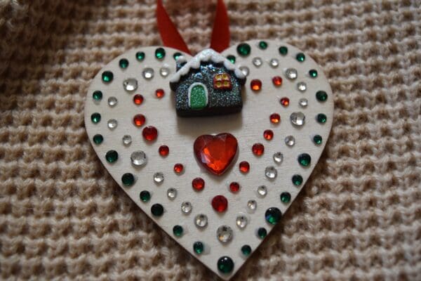 A heart shaped ornament with red and green rhinestones.