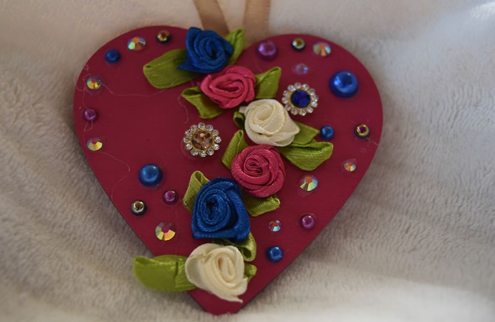 A heart shaped ornament with flowers on it.