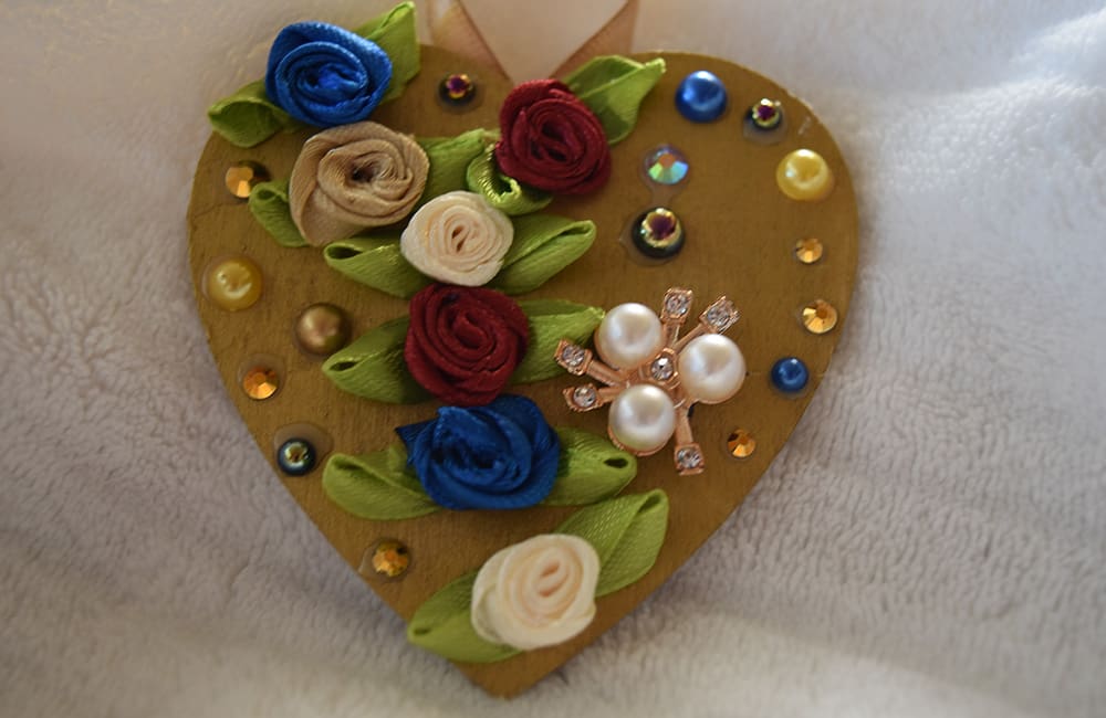 A heart shaped decoration with flowers and beads.