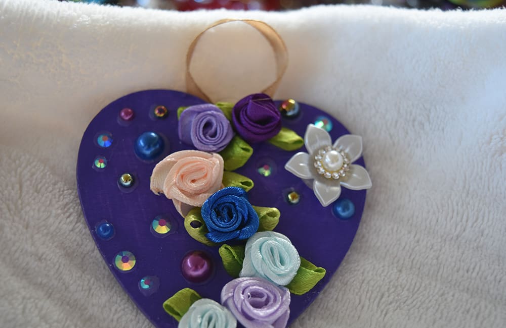 A purple heart with flowers and jewels on it.