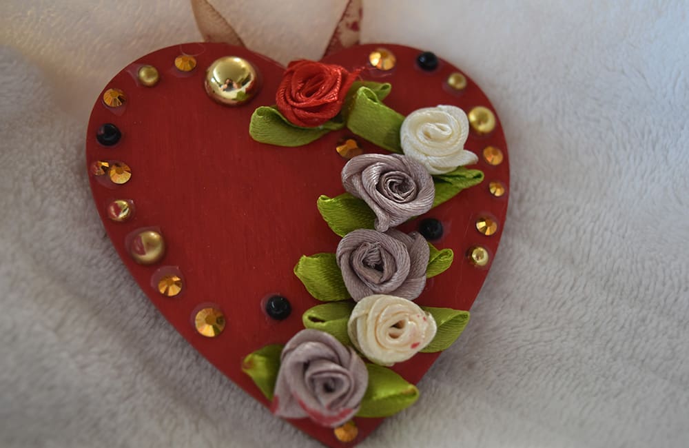 A heart shaped ornament with flowers on it.