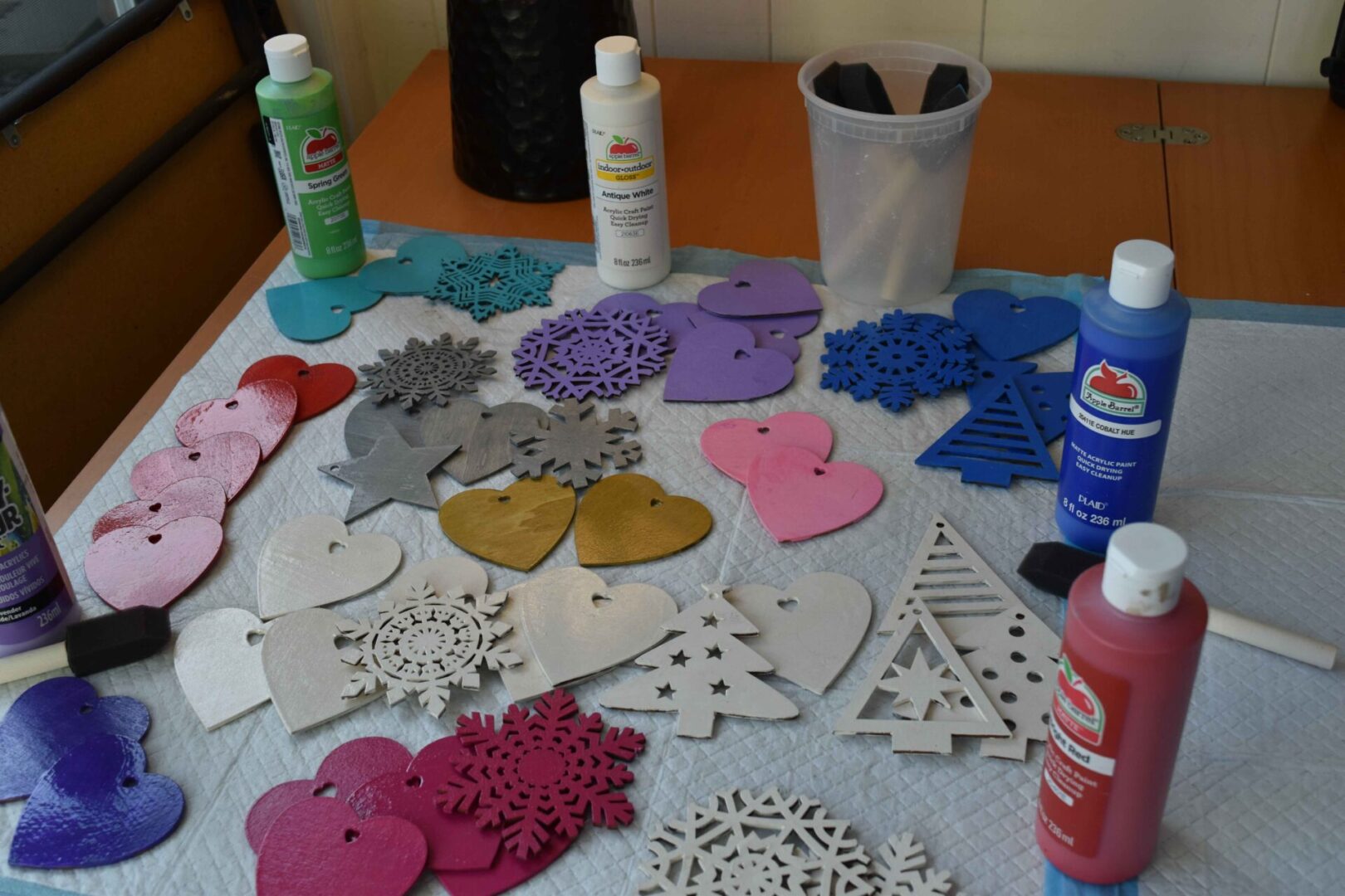 A table covered with various colored paper hearts and paint.